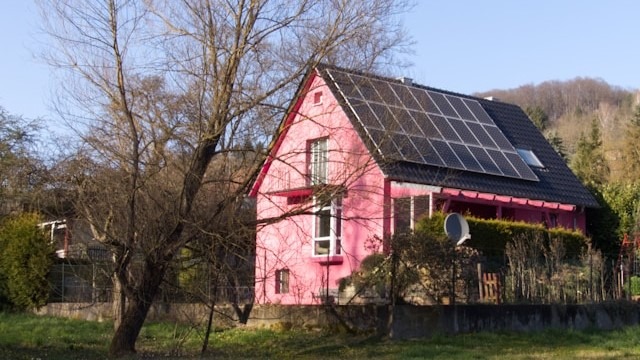 różowy dom z fotowoltaiką na dachu